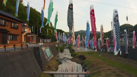 carp windsock streamers along rural river in japan noto peninsula