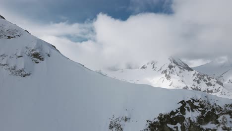 panning into a mountainside, slowmotion drone shot of the pirin mountain vihren, in bulgaria