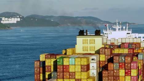 a close-up parallax shot of a large container vessel with dirty fumes sprawling from its chimney