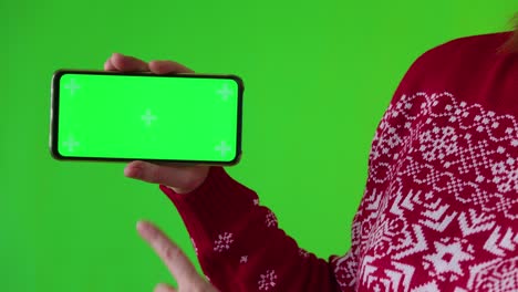 female shows phone with green screen