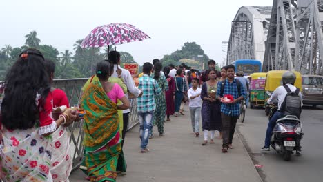 crowds of people walking on a bridge in india
