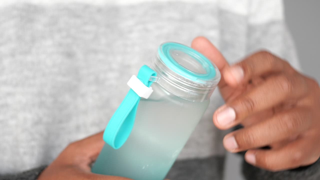 persona que sostiene una botella de agua