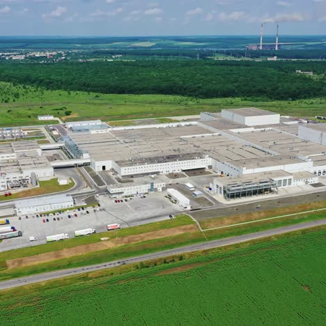 modern factory in the countryside. huge industrial complex among picturesque green fields. new manufacture among nature. aerial view.