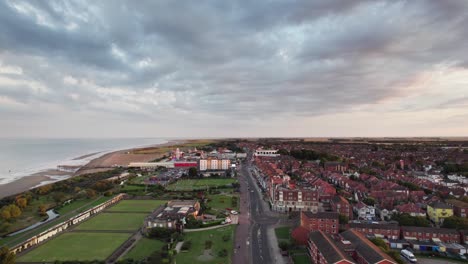 Hoch-Oben-Bieten-Videoaufnahmen-Einen-Blick-Auf-Eine-Atemberaubende-Sonnenuntergangsszene-über-Skegness,-Einer-Entzückenden-Küstenstadt-Im-Vereinigten-Königreich,-Mit-Der-Stadt,-Der-Promenade,-Dem-Pier-Und-Der-Küste