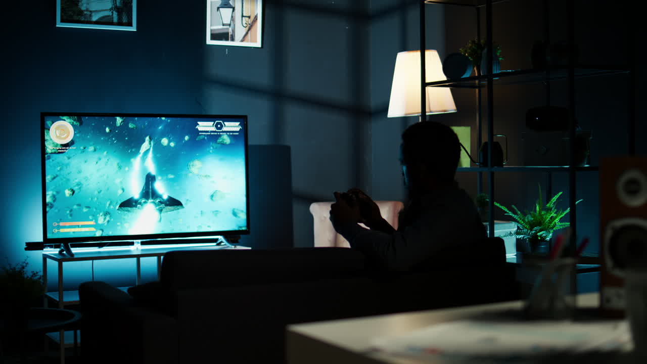 Gamer adulto di colore che vince un torneo di sparatutto online di notte