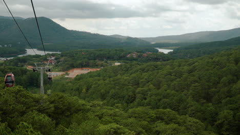 POV-Shot-of-Dalat-Cable-Car-Ride-Moving-Over-Stunning-Mountain-Valley-Hills-and-Lush-Green-Forests,-Vietnam