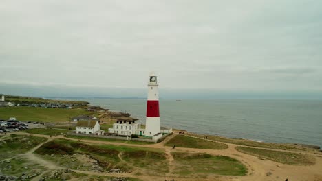 Faro-Rojo-Y-Blanco-De-Portland,-Reino-Unido,-Drone-Fly-Away-Shot