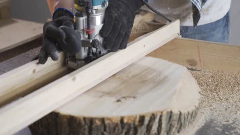 a man in a gloves processes a wood slice with a miller