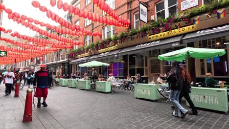 people walking under red lanterns in chinatown