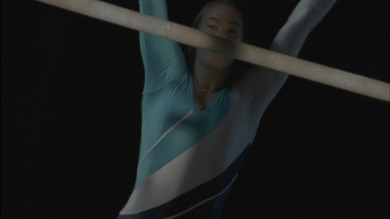 여자 체조 선수가 평행봉에서 연기를 하고 있다