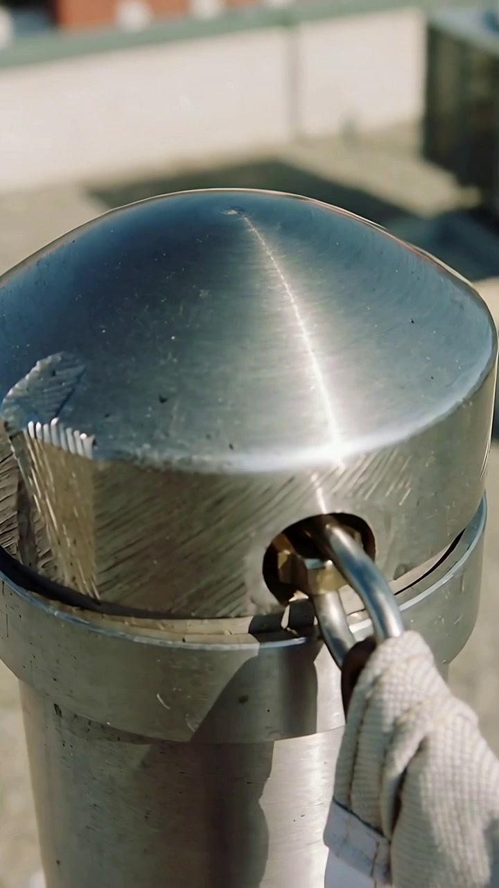 Video verticale: Far scorrere un grillo metallico in un palo di acciaio inossidabile sul tetto, fissando una cinghia di tessuto.