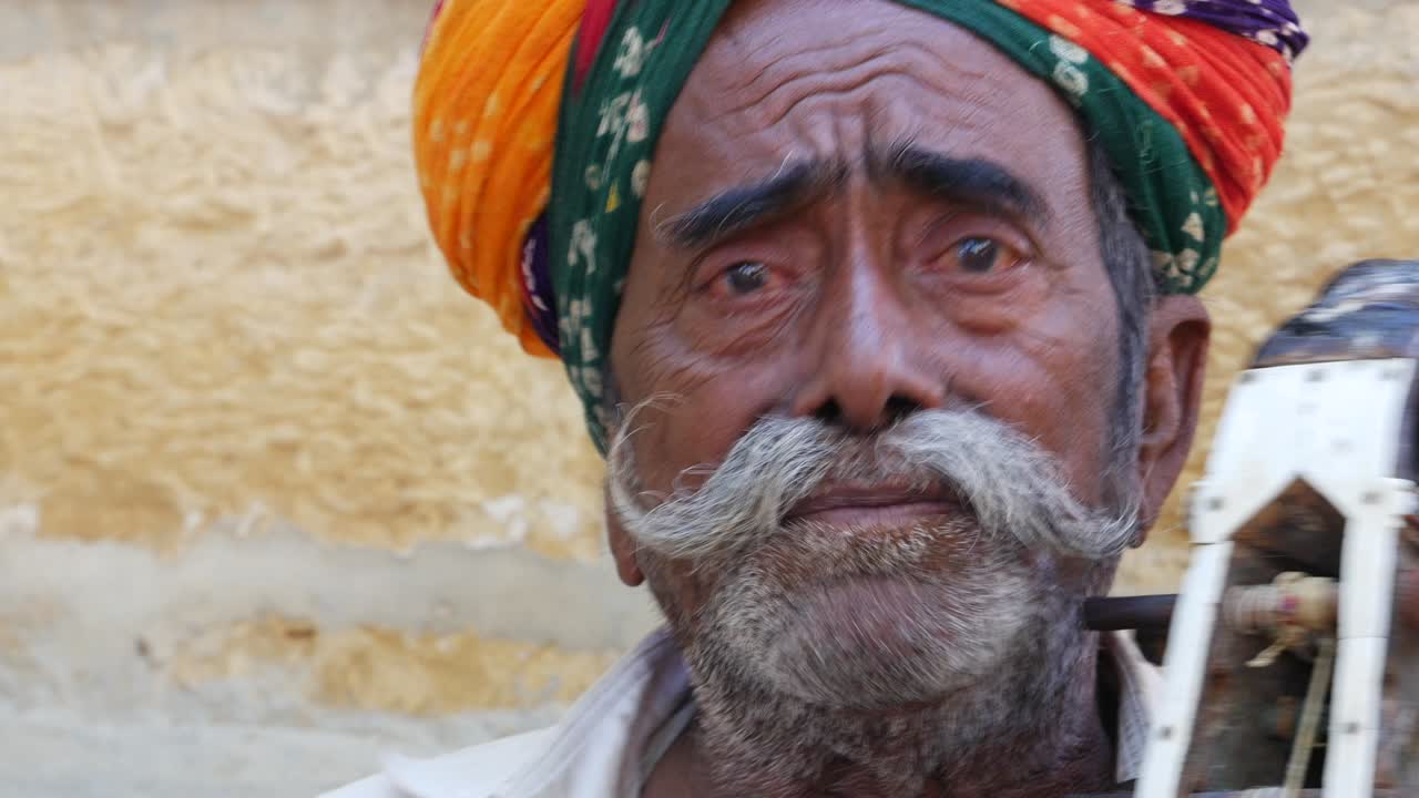 Indian Man plays traditional musical instrument in Jaisalmer Fort, Rajasthan, India