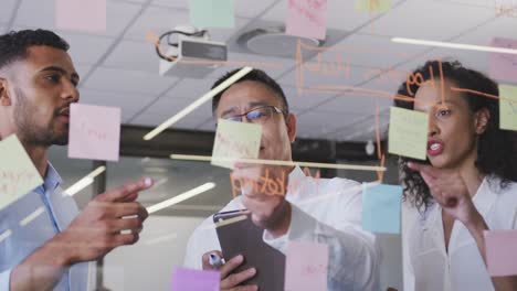 senior businessman with digital tablet discussing with young business people over memo notes