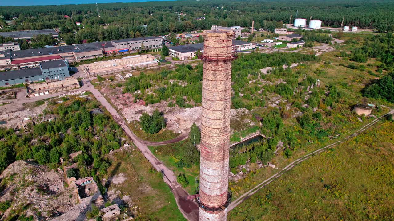 Aerial view of an industrial site with a chimney in Latvia