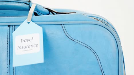 Travel-insurance-label-tied-to-a-suitcase