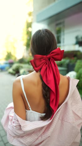 woman with pink shirt and red bow