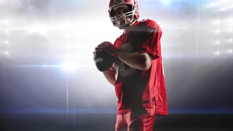 Animation-of-male-american-football-player-holding-ball-at-floodlit-stadium