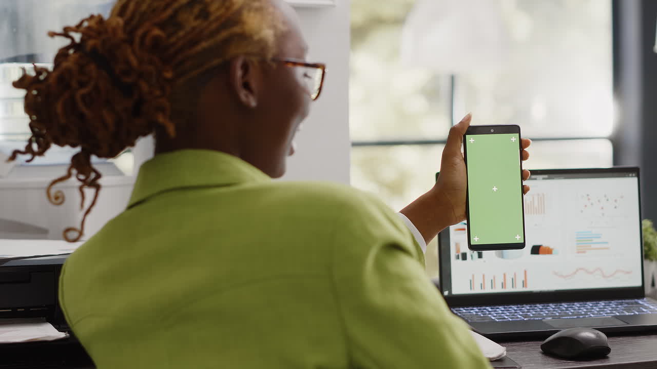 Woman holding phone with green screen