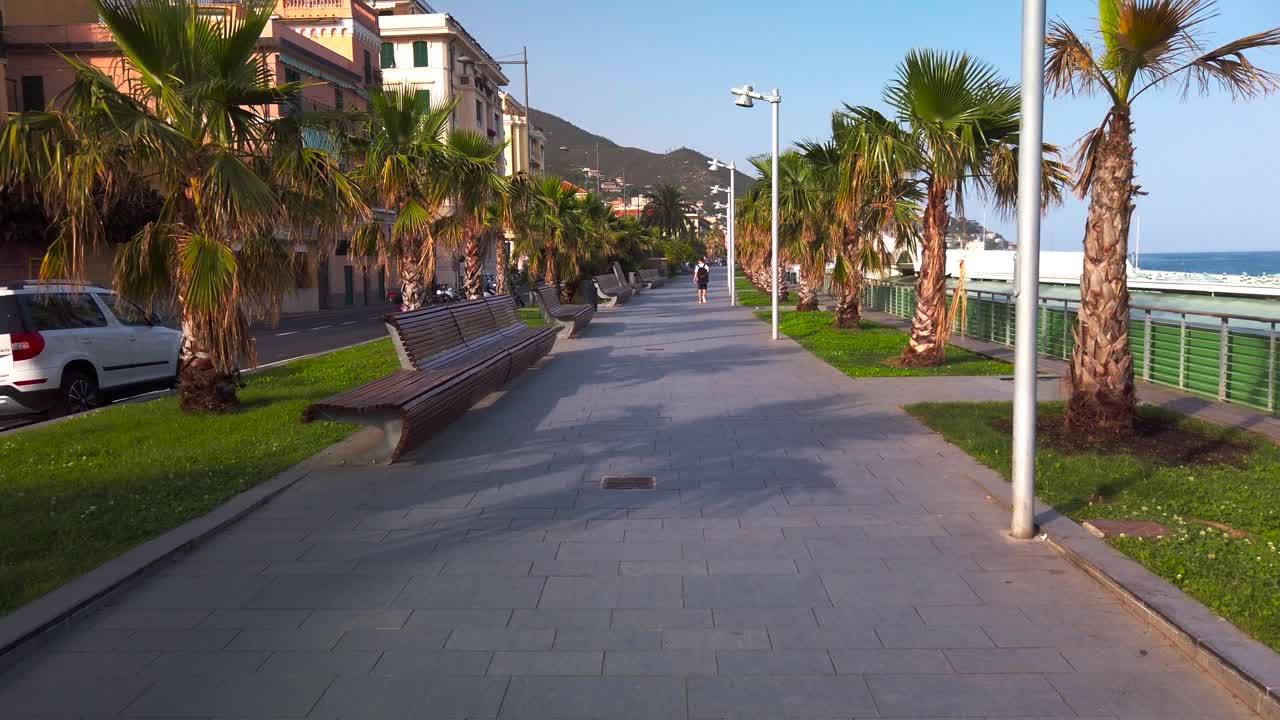Lungomare di Varazze al tramonto con una sola persona che cammina da sola.