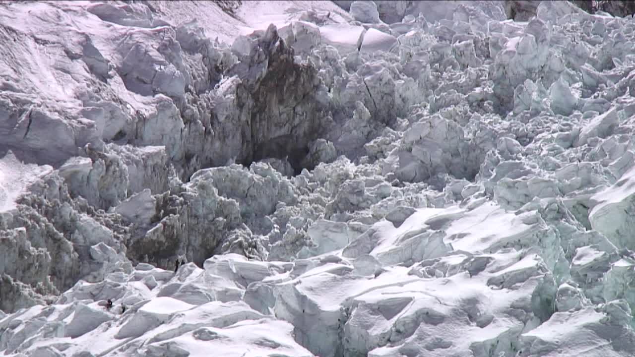 escaladores en cascada de hielo que parecen pequeños