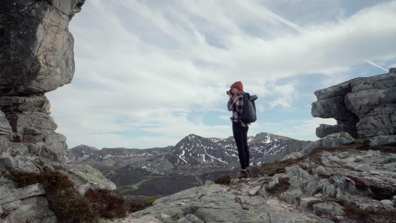 Female taking pictures of the high mountains in the nature of Spain. Wide shot