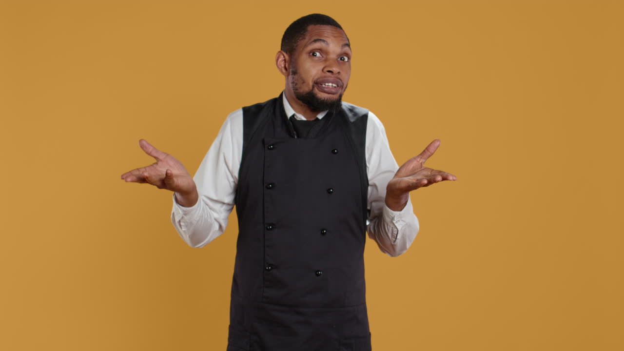 Professional waiter showing clueless sign and being unsure