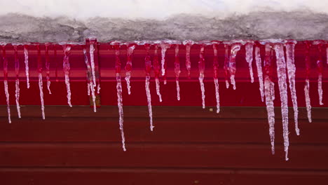 tiro de lapso de tiempo de carámbanos emergentes en el techo de la casa durante el frío día de invierno