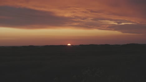 sunset over a calm landscape with vibrant orange and purple skies