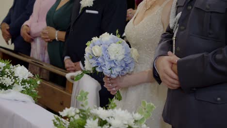 the bride holding a wedding bouquet, standing next to the groom during the ceremony