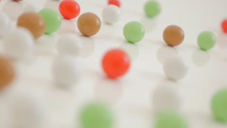 various color bonbons on the white shiny and reflective background 4k 3840x2160 uhd video - mixed color round candies on the white surface 4k 2160p 30fps ultrahd footage