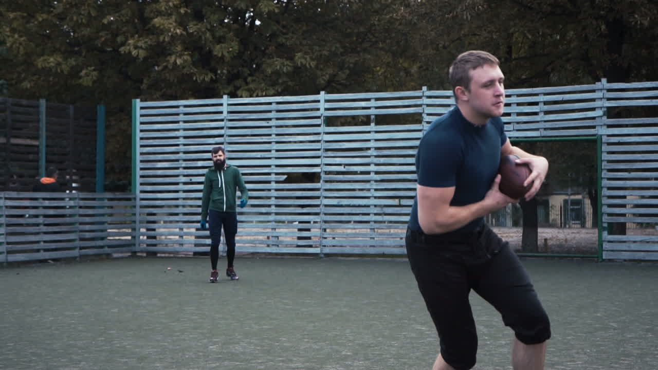 Men playing American football on an outdoor field