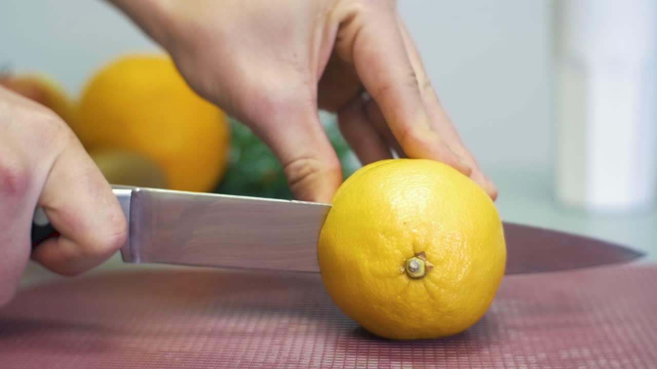 SLOW MOTION mentre si taglia un limone in due parti con un coltello.