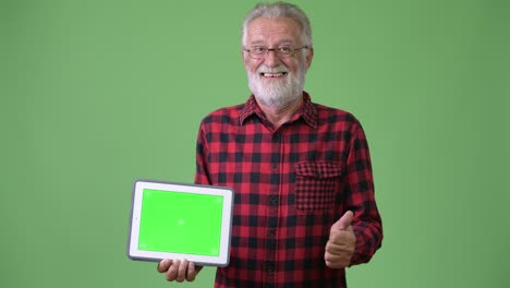 hombre de barba viejo y guapo contra un fondo verde.