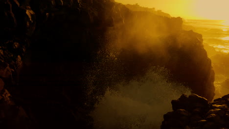 golden sunset over rocky coastline with powerful waves