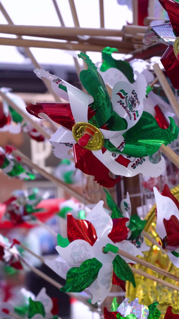 Mercado del día de la independencia de México vende decoraciones de molinillos con forma de águila, adornos de papel de aluminio rojo, blanco y verde en primer plano