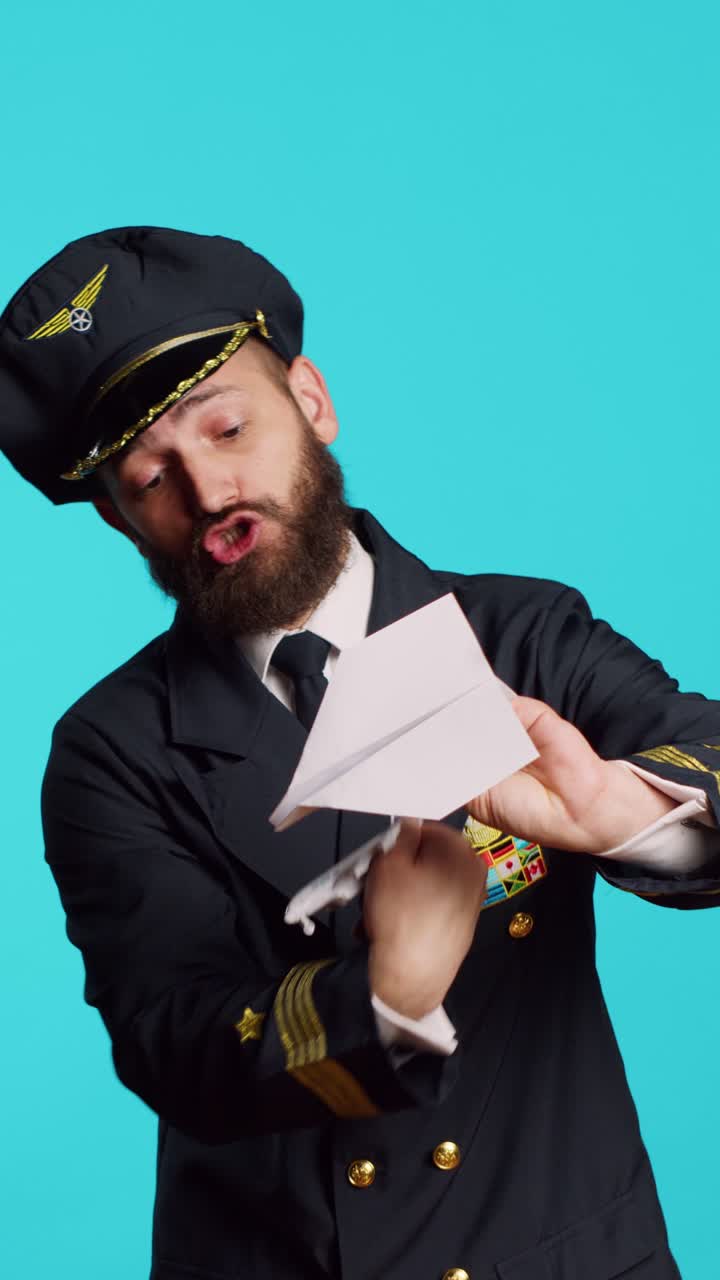 Video verticale: pilota di linea che gioca con un aeroplanino di carta
