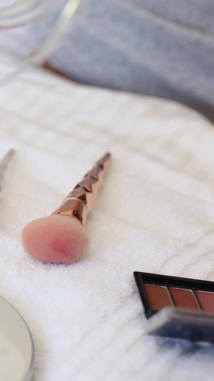 Vertical video: Reaching woman picking red tool at home vanity, arranging brushes and palette