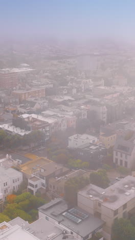 thick white fog spreading over the city. aerial footage of beautiful san francisco scenery being covered with haze. vertical video