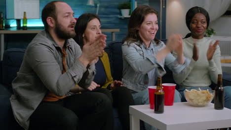 mixed race people cheering together while looking at soccer