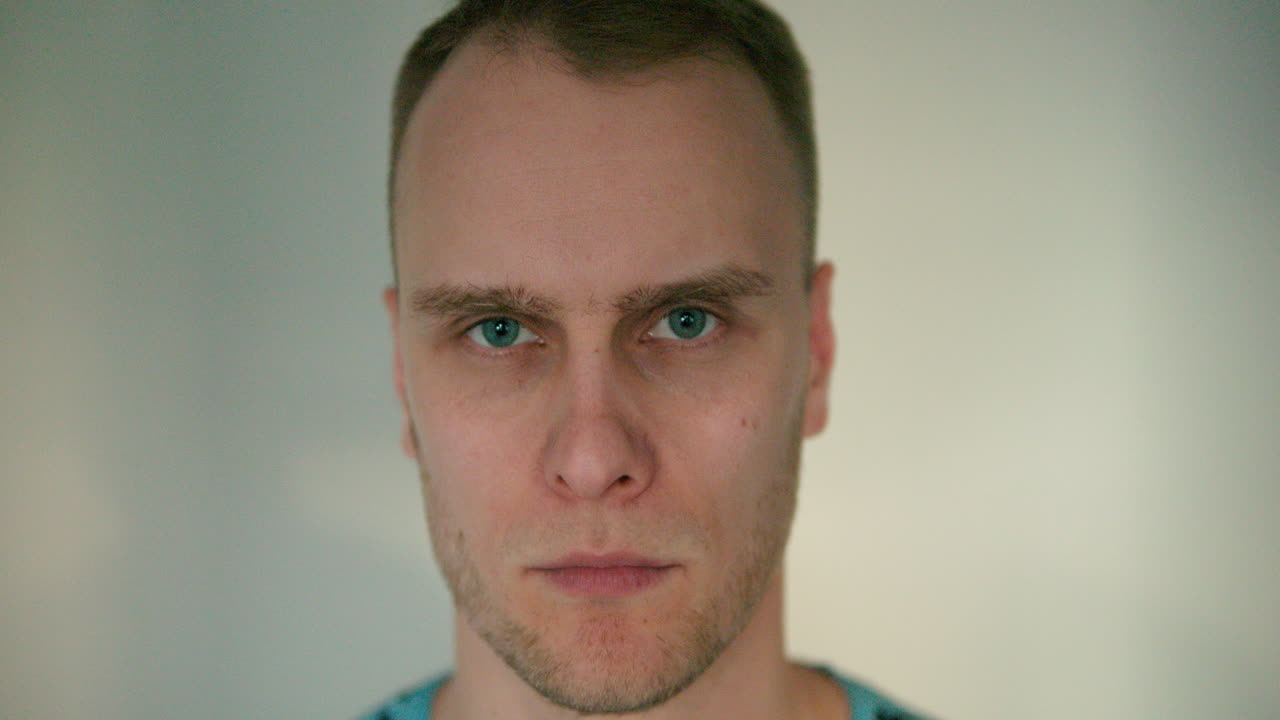 primer plano de un joven que mira enojado a la cámara