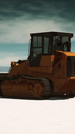 orange tracked bulldozer in snowy landscape