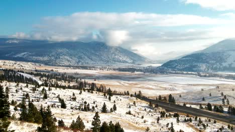 cinematic scene of the highway 5a surrounded by trees,grassland mountains of the nicola valley in winter, snow covered landscape with sunshine close to merritt, bc canada