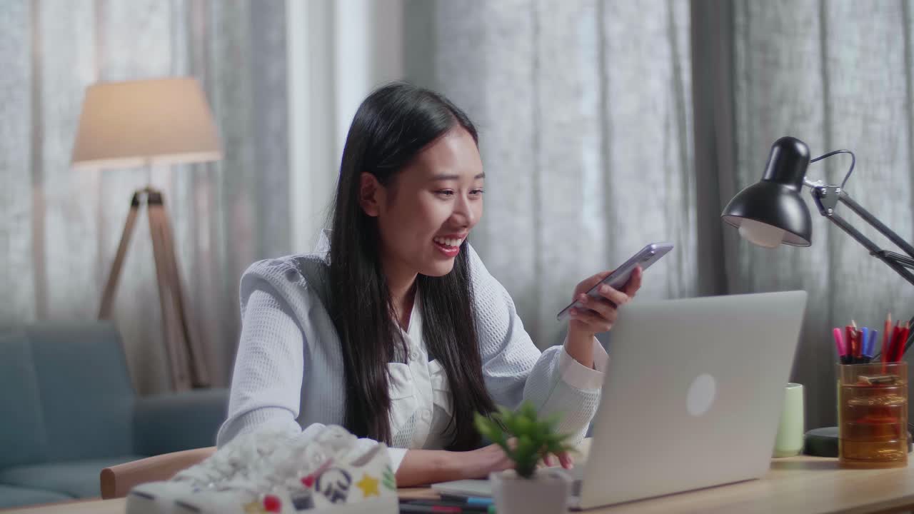 노트북과 스마트폰으로 집에서 일하는 여성