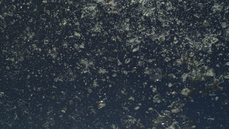 motion shot of spray particles exploding from ocean in dense misty blast at night