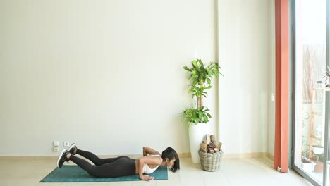 Ethnic-sportswoman-jumping-during-workout-in-room