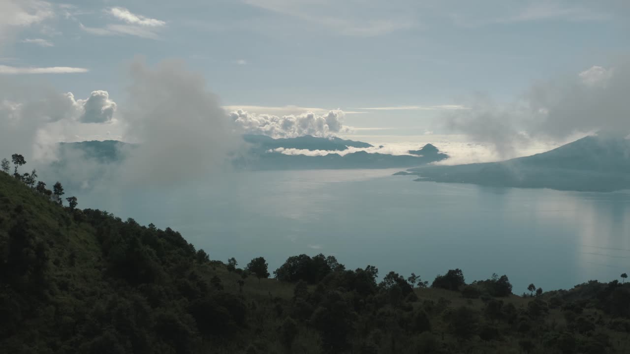 vista aérea de drones volando sobre las montañas revelando el hermoso lago azul atitlan, guatemala