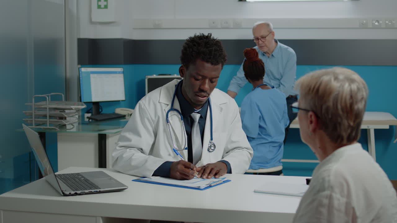 Medico afroamericano che consulta un'anziana malata