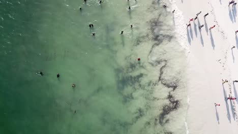 People-swimming-and-walking-on-beautiful-sandy-beach-of-Watamu,-Kenya