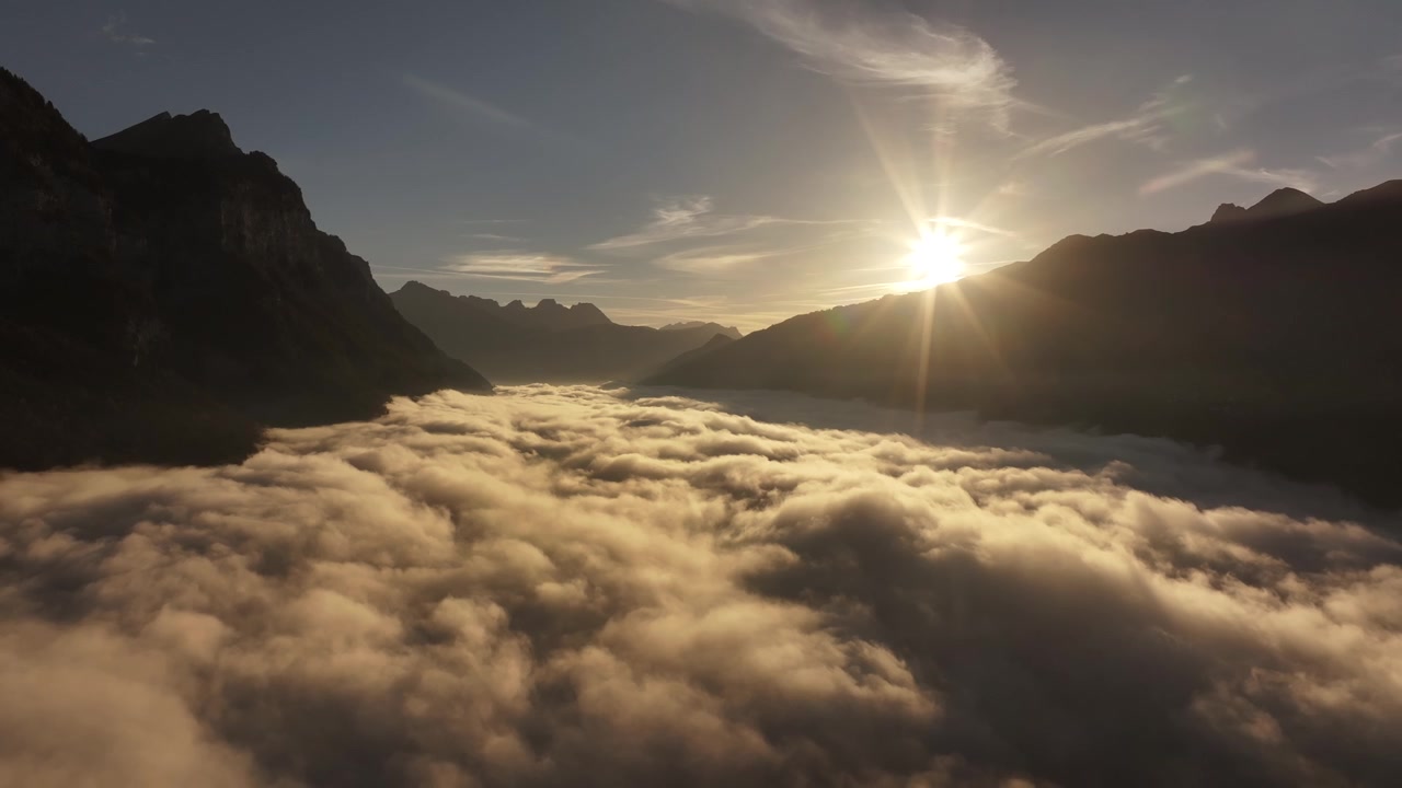 Il drone si allontana lentamente sopra uno strato di nuvole soffici e vaporose annidato tra le Alpi svizzere a Quinten, Walenstadt, Svizzera