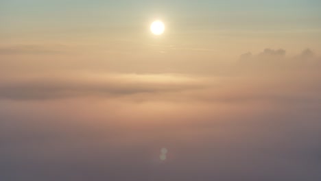 Vista-De-Drones-Del-Amanecer-Dorado-Mientras-Desciende-Hacia-La-Niebla-De-La-Mañana